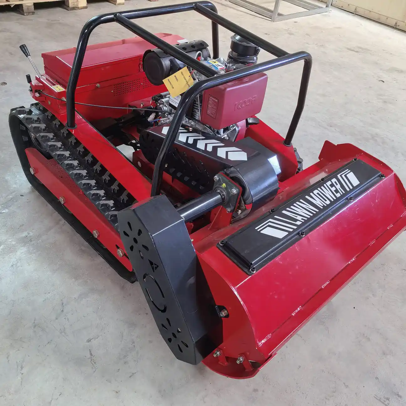 Engine, cutting deck, and rubber track details on a remote control mower