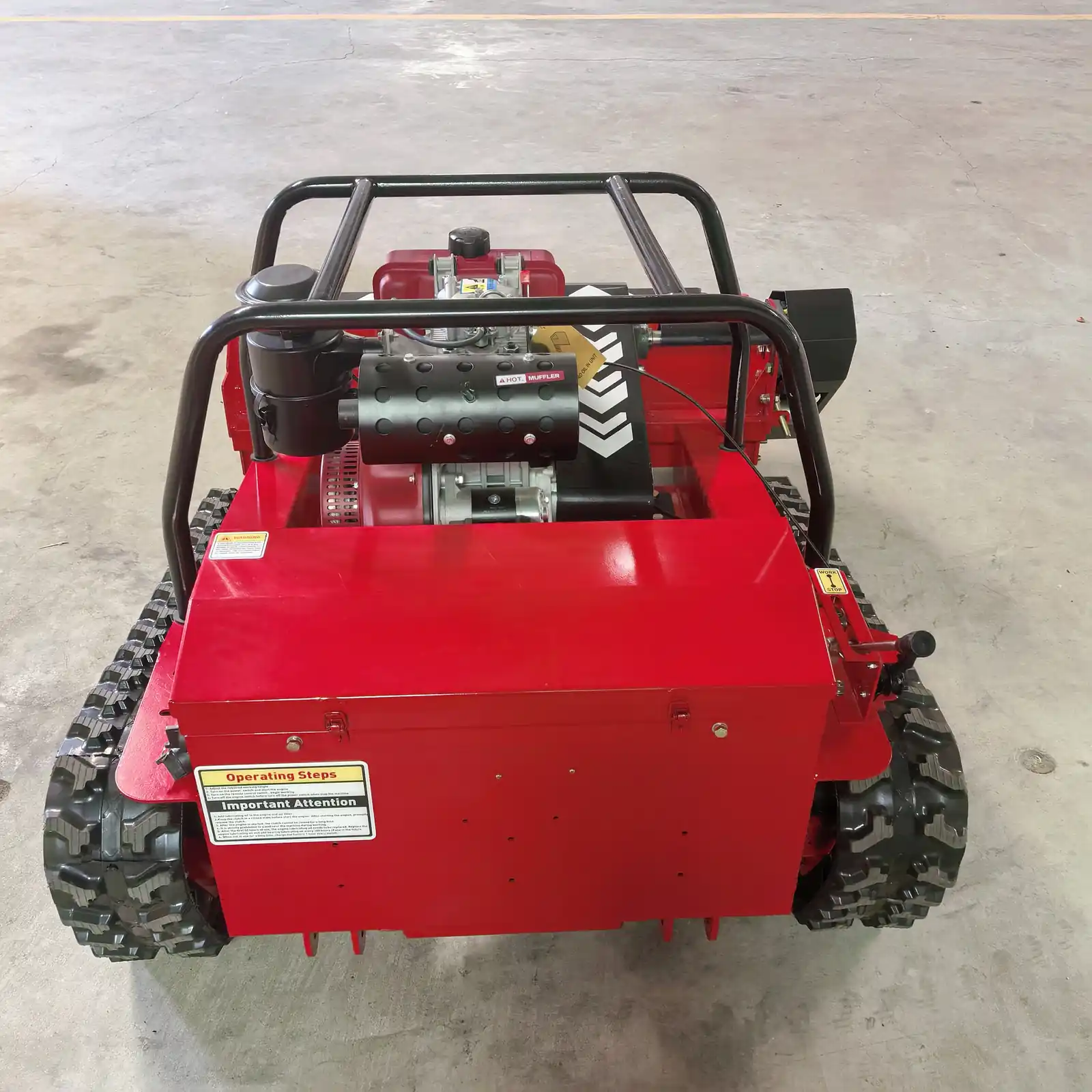 Rear view of a remote mower showing the dual rubber track layout