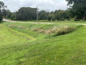 Canadian roadside property with a grass ditch, road shoulder, and gentle cross-slope