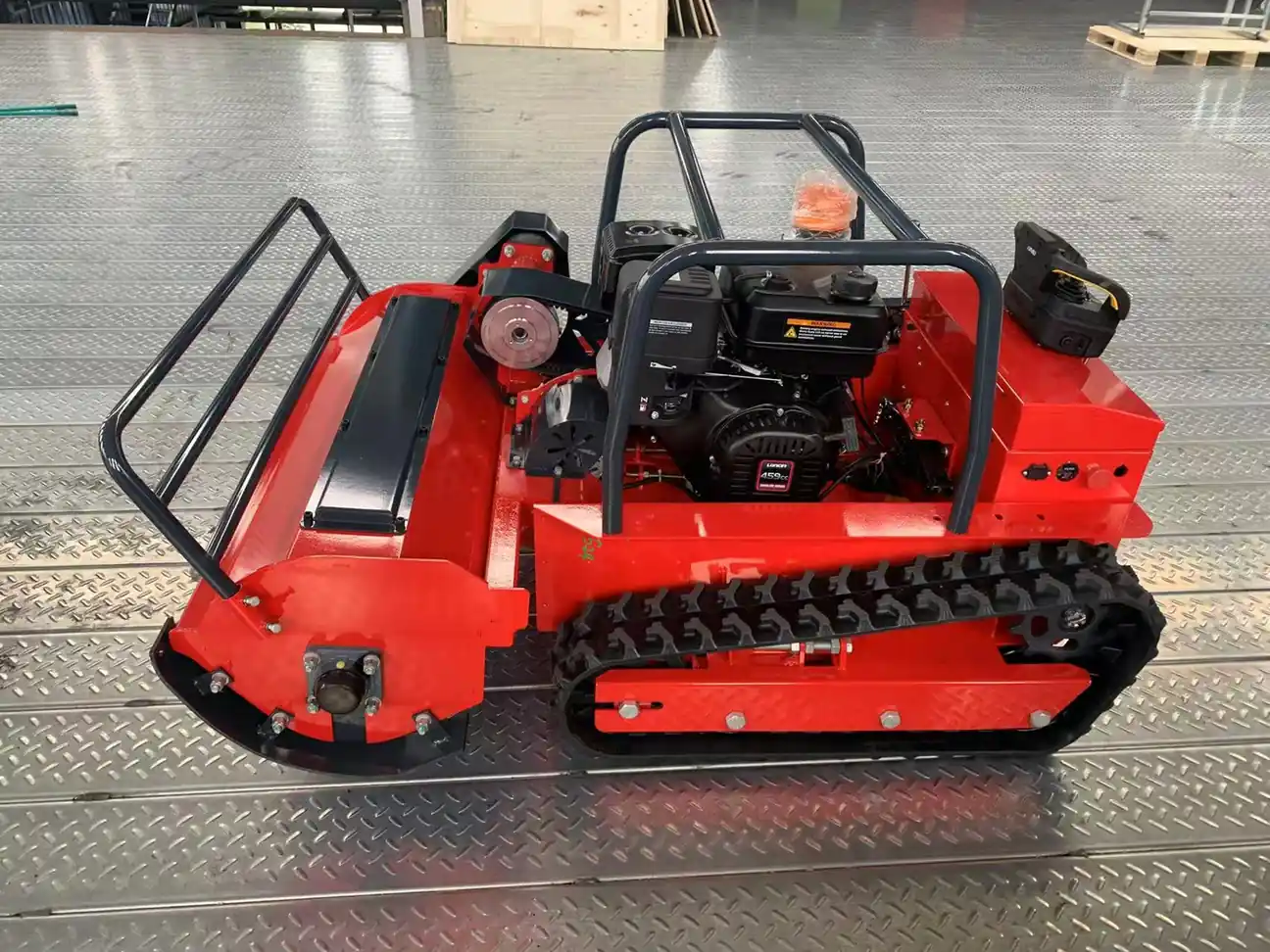 Gasoline tracked remote mower displayed on a factory floor