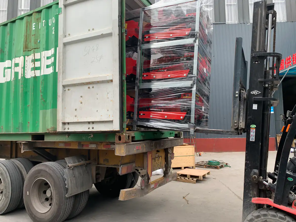 Forklift loading packed MERI mowers into an export container