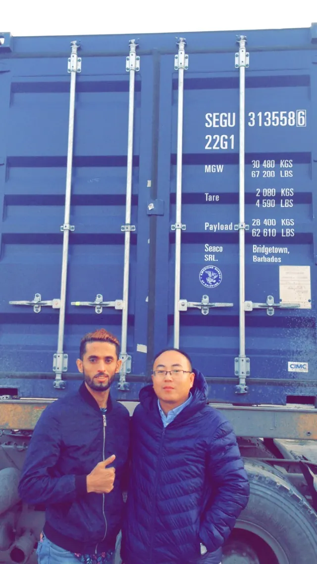 Customer and MERI team beside an export container