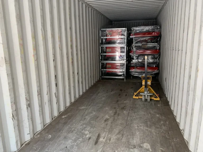 Wrapped remote mower units secured at the front of a shipping container