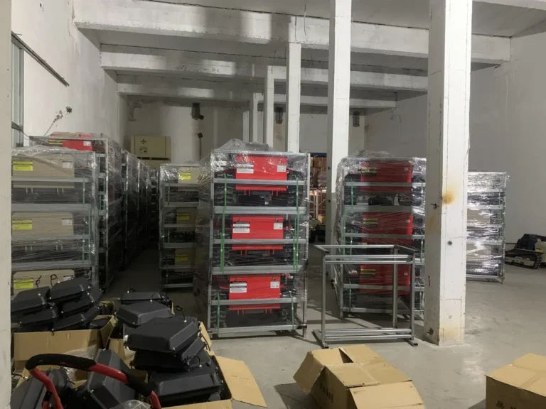 Remote mower units wrapped in metal transport frames inside a factory