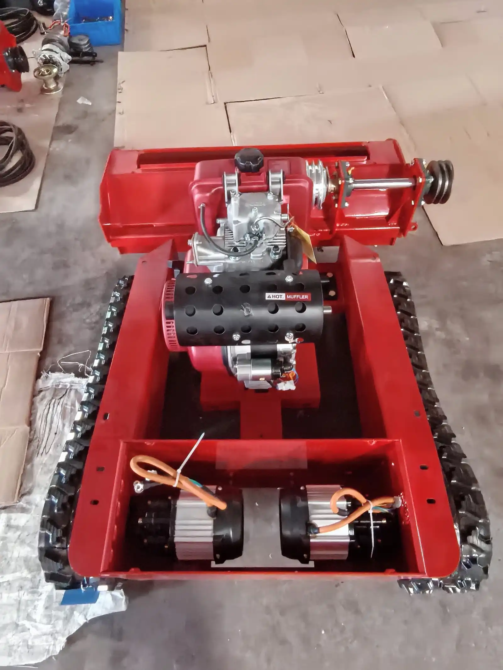 Open tracked mower chassis showing the engine and electric drive motor layout
