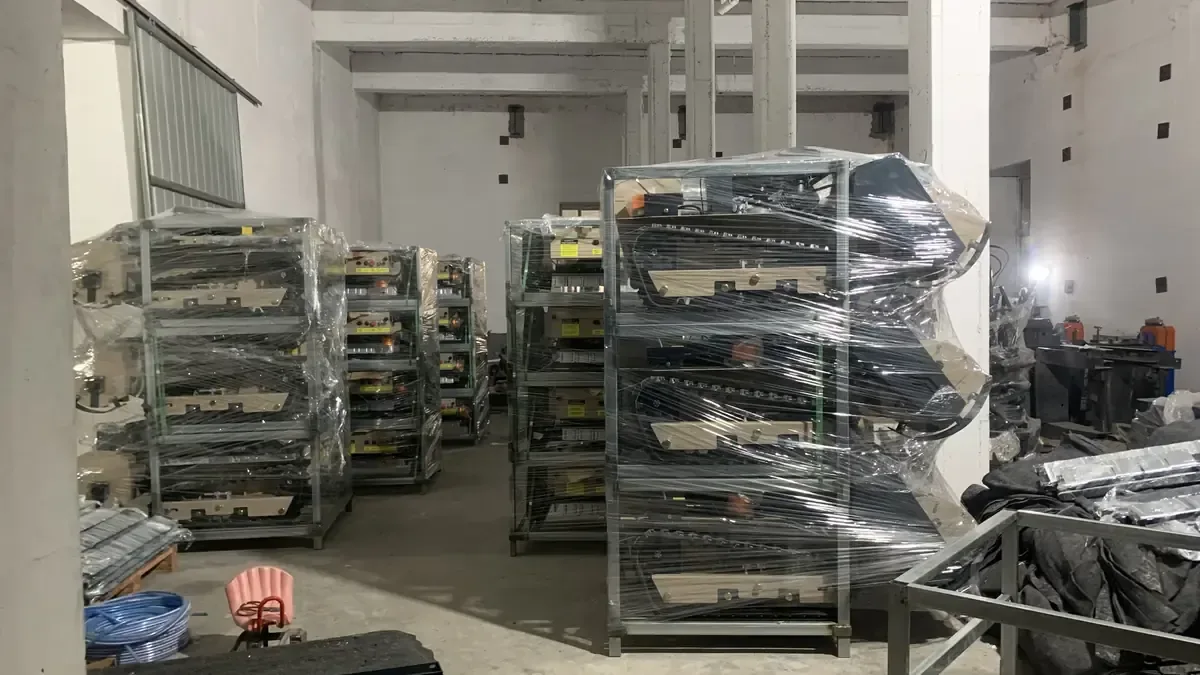 Remote mowers in metal transport racks during factory delivery preparation