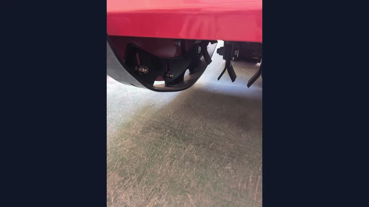 Close workshop view of a mower rotor end and pivoting flails