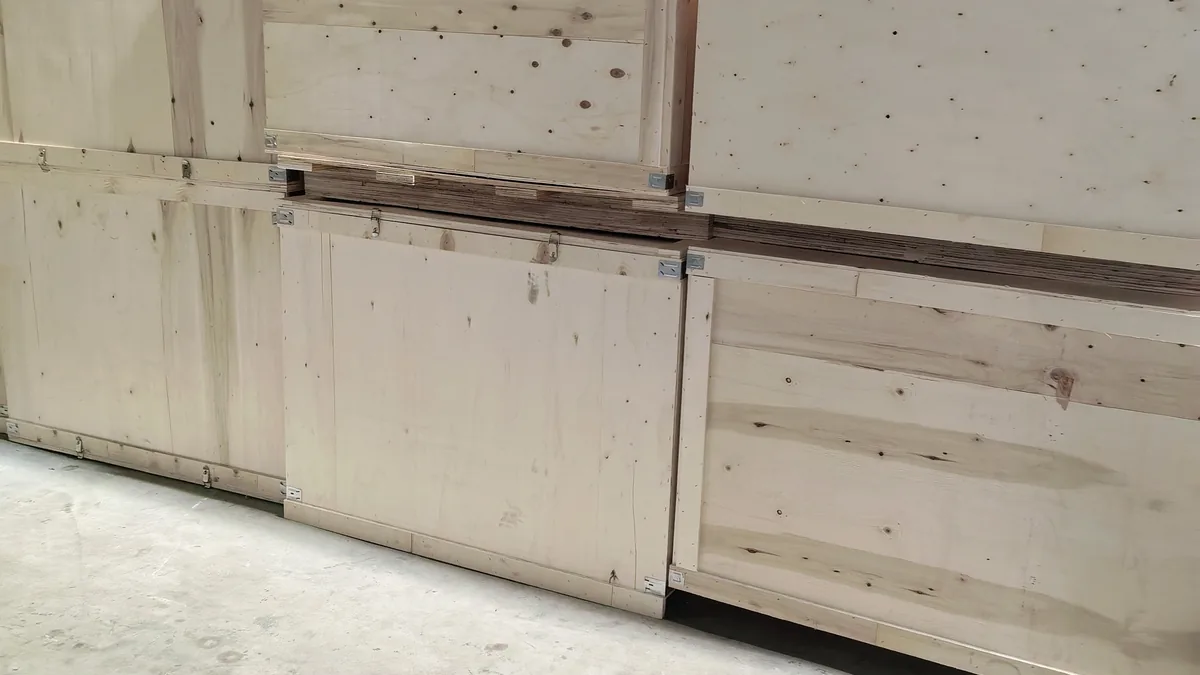 Plain closed wooden shipping crates stacked in a factory loading area